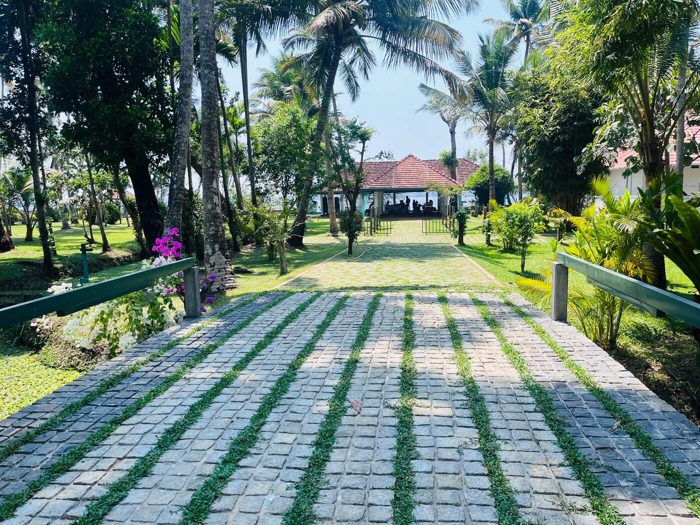 Stone pathway leading to an open-air pavilion by the water
